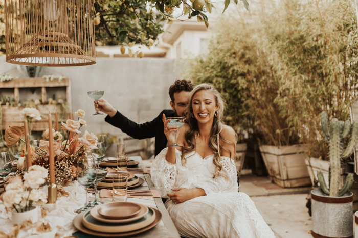 bride holding cocktail at backyard wedding